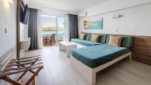 a hotel room with a couch and a table at Globales Verdemar in Santa Ponsa +37 photos