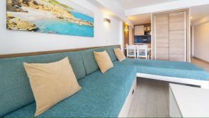 a living room with a blue couch in a room at Globales Verdemar in Santa Ponsa