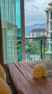 a room with a window with a table with flowers on it at Nimman Condo,Mountain View in Chiang Mai