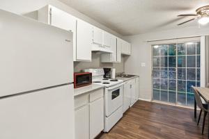 Una cocina con electrodomésticos blancos y una mesa con sillas. en Kenridge Apartments 2615 I Comfy 2 Bed 2 Bath, en Decatur