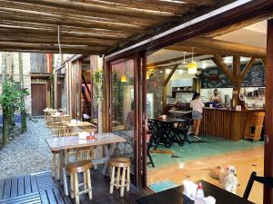 a restaurant with wooden tables and chairs and a kitchen at Lalabella Itaguá in Ubatuba