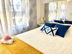 a bedroom with a large bed with blue pillows at Casa da Praia na Torre Castelo in Armação de Pêra +22 photos