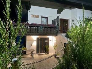 ein Innenhof eines Hauses mit einem Balkon und einer Bank in der Unterkunft Haus Salzkristall in Obertraun