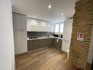 cocina con armarios blancos y suelo de madera en Foro Romano Apartments D, en Roma 19 fotos más