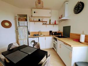 eine Küche mit einem Esstisch und eine Küche mit einem Herd in der Unterkunft Appartement charmant dans le centre de Biarritz Dan 3ème étage in Biarritz