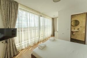 a bedroom with a bed and a large window at апартаменти Пасажио in Sandanski