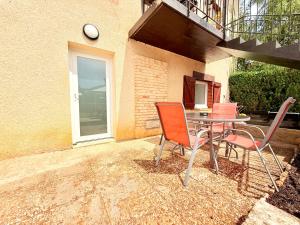 a patio with a table and chairs in front of a building at Appartement 2 Personnes Terrasse privée in Ornans