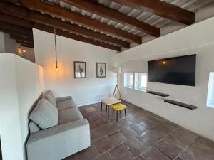 a living room with a couch and a flat screen tv at AmazINN Places Casa Calabuig Ático Marina Real - No Ascensor- in Valencia