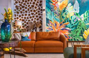 a living room with a couch and a colorful wall at Hotel Village Enseada in Ubatuba