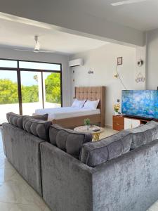 a living room with a large couch and a bed at Fantasea Villa in Ukunda Airport