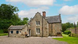 an old stone house in the middle of a field at Gardener's Cottage, Twizell Estate in Belford