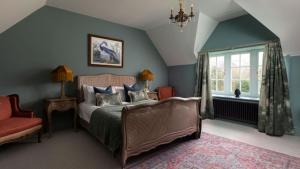 a bedroom with a bed and a chair and a window at Gardener's Cottage, Twizell Estate in Belford