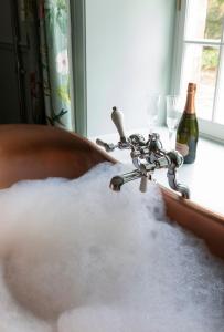 a sink filled with snow next to a bottle of wine at Gardener's Cottage, Twizell Estate in Belford
