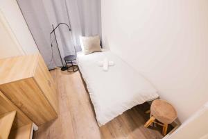 a small bedroom with a white bed and a stool at Stylish 50m2 Two-Bedroom Apartment - SD23K in Eindhoven +33 photos