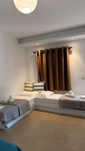 two beds in a room with a window at Rida Village Ksamil Island in Ksamil