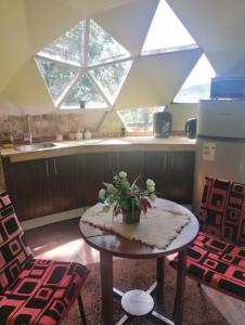 a kitchen with a table and two chairs and a window at Domos Temuco, Cumbres del Conunhuenu in Temuco