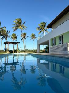 バイシオにあるBeach house - secured, beach access, sea view, best locationのヤシの木が茂る家の前のスイミングプール