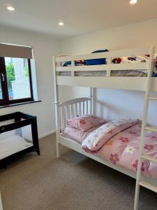 a bedroom with two bunk beds and a mirror at Sienna Cottage in Benllech