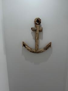 a wooden cross hanging on a wall at Sienna Cottage in Benllech