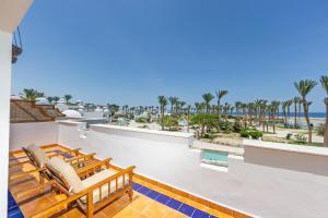 a balcony with chairs and a view of the beach at Grand Makadi - Couples and Families Only in Hurghada