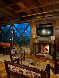 a living room with a fireplace and a tv at Hotel de Montaña El Pelicano in San Isidro