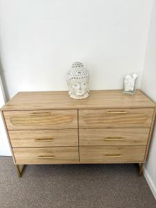 a wooden dresser with a mask on top of it at Sienna Cottage in Benllech +36 photos