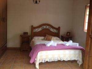 Schlafzimmer mit einem Bett mit rosa und weißer Bettwäsche in der Unterkunft Casa rural La Encantadora in Vallehermoso