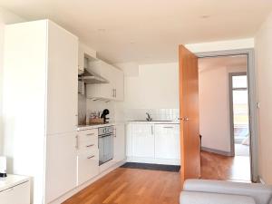 une cuisine avec des armoires blanches et une porte ouverte dans l'établissement York City Centre 2-Bed Flat - Top Location, à York