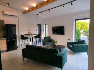 una sala de estar con 2 sofás verdes y una mesa. en Apartman Oli 1, en Poreč