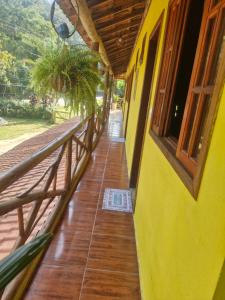 een gang van een geel gebouw met een veranda bij Refúgio do Paraty Mirim in Paraty +10 foto's