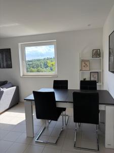 a dining room with a table and chairs and a window at Ferienwohnung Weitblick nahe Göttingen in Hardegsen