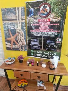 een tafel met een bordje op een gele muur bij Refúgio do Paraty Mirim in Paraty