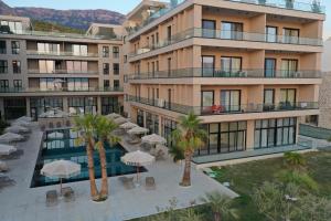 een appartementencomplex met een zwembad en palmbomen bij Casa Magnolia in Vlorë