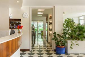 a lobby with potted plants and a counter at Hotel Croce Di Malta in Lignano Sabbiadoro