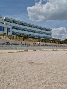 a building on the beach with a sign on it at Hotel Azur in Costinesti