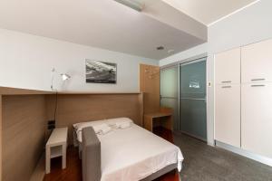 a bedroom with a bed and a table and a cabinet at Appartamento in Centro 10' Stazione in Turin