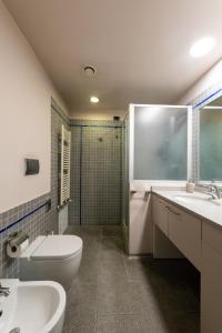 a bathroom with two sinks and a toilet and a shower at Appartamento in Centro 10' Stazione in Turin +18 photos