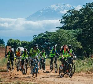 a group of people riding bikes on a dirt road at Milele Homestay in Boma la Ngombe
