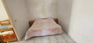 Dormitorio pequeño con cama con manta en une chambre, un salon, cuisine et balcon, en Monastir