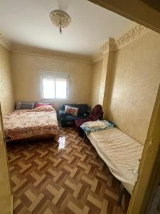 a room with two beds and a couch in it at ezzaimi apartment playa in Tangier