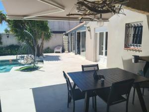 Un patio con mesa y sillas y una piscina. en Villa Besne, en Thuir