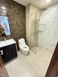 a bathroom with a toilet and a glass shower at Arcadia Beach Resort Tatil Merkezi in Pattaya South