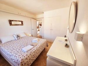 Face à la mer appartement vue mer Portiragnes plage proche Cap d'agde Vias Valras-plage Méditérranée في بورتيراني: غرفة نوم صغيرة مع سرير وطاولة