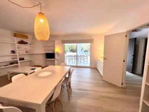 a dining room with a white table and chairs at Casa immersa nel verde a pochi passi dalla playa in Illes Balears +14 photos