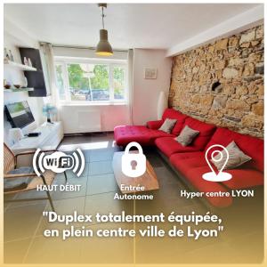 ein Wohnzimmer mit einem roten Sofa und einer Steinmauer in der Unterkunft Duplex central à Lyon pour 5 personnes in Lyon