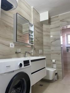 a bathroom with a washing machine and a toilet at Apartment Katerina in Himare