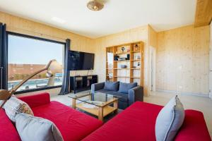 a living room with a red couch and a large window at Victoria Atlantica in Sagres
