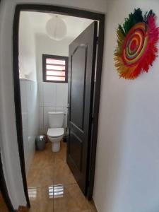 a bathroom with a toilet and a door with a mirror at Villa De la mer au volcan in Saint-Pierre +19 photos