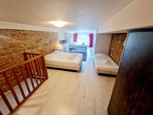 a bedroom with two beds and a stone wall at Grand duplex 5 pers au cœur de Lyon Opéra & métro in Lyon