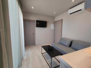 a living room with a blue couch and a table at LIViT Condo Elafonisi in Agios Padeleimon